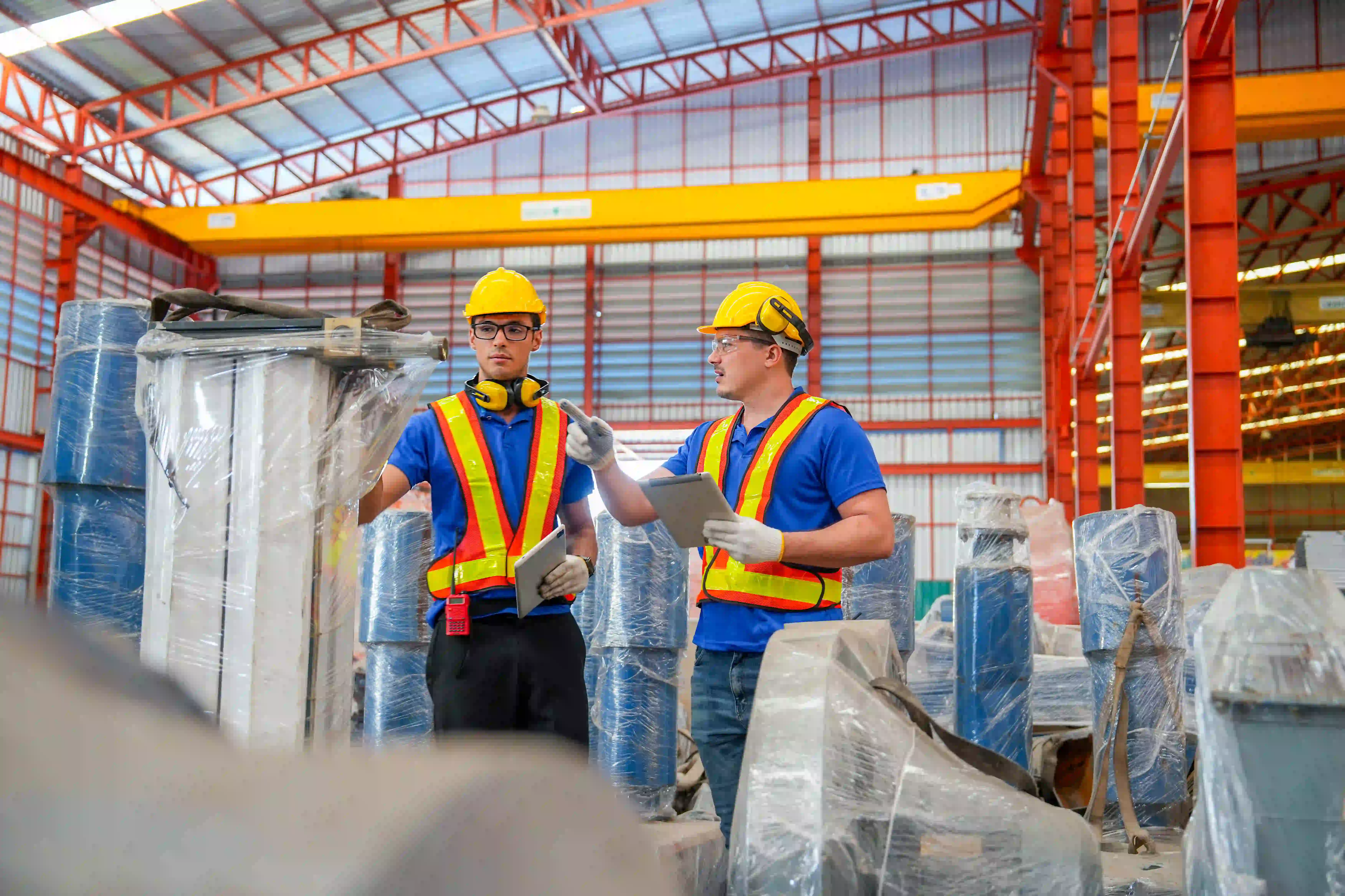 Two factory workers with safety gear inspecting equipment - Verhuren van technisch personeel